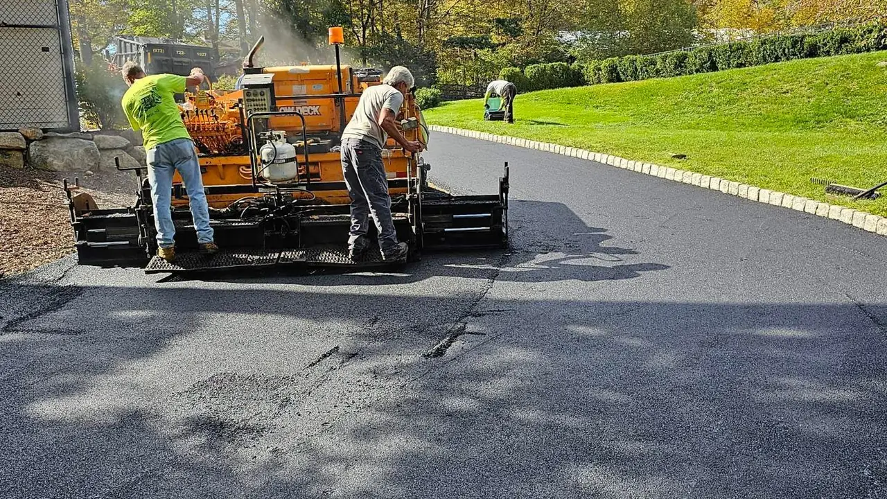 Paving crew working behind the paver on a fresh asphalt mat