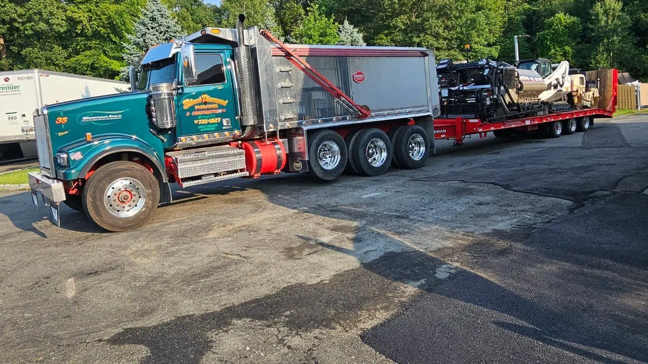 Patched and worn asphalt at a gas station forecourt before repair