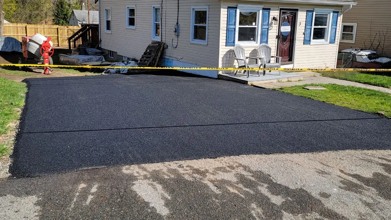 Freshly paved asphalt driveway at a two-story New Jersey home